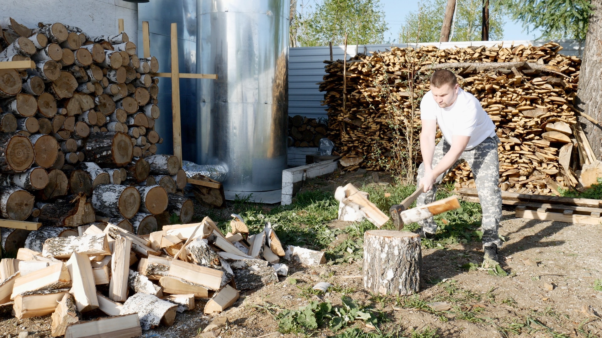 woman in white t-shirt and gray pants holding firewood